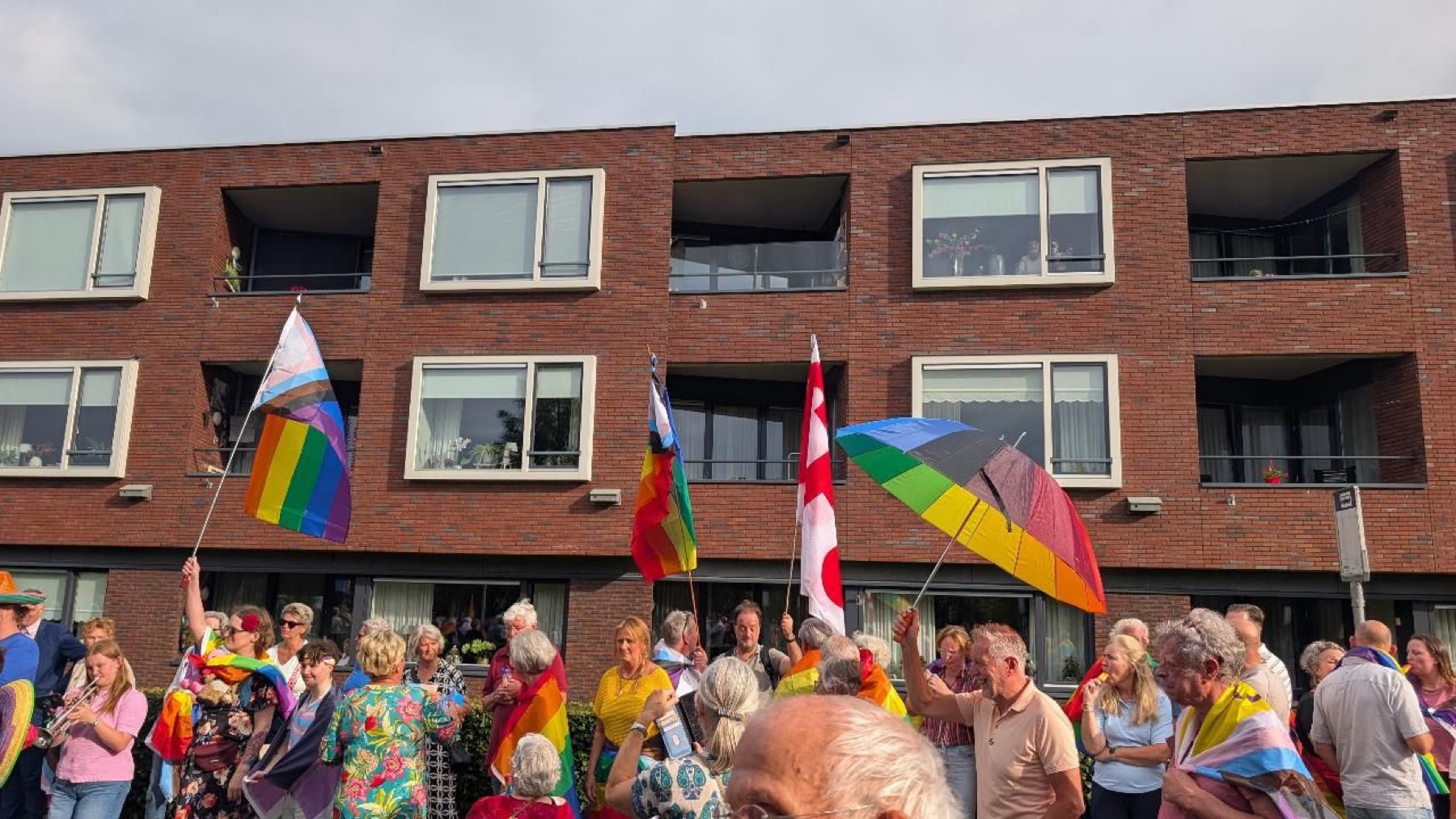 Regenboogvlaggen aan balkons van een appartementengebouw